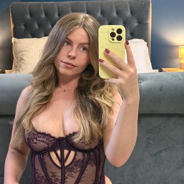 Woman taking a bedroom selfie in lingerie.