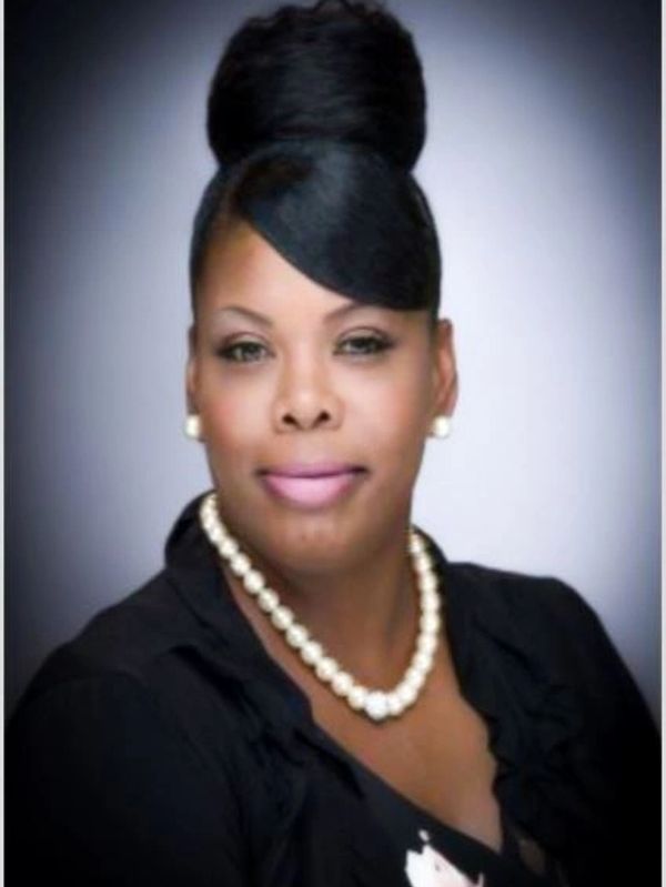 Professional woman with pearl necklace and elegant hairstyle.