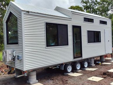 A modern tiny house on wheels with corrugated metal siding.
