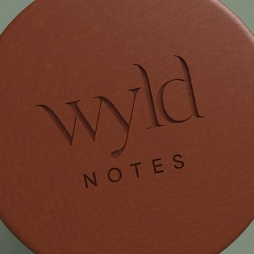 Close-up of a brown leather cover with 'wyld NOTES' embossed on it.