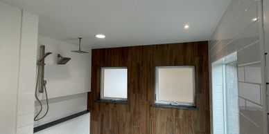 Modern bathroom with wood-effect tiles and dual shower heads.