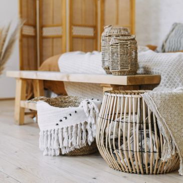 A bedroom shot showing a bed and its surroundings in natural rattan and bamboo, and neutral colours