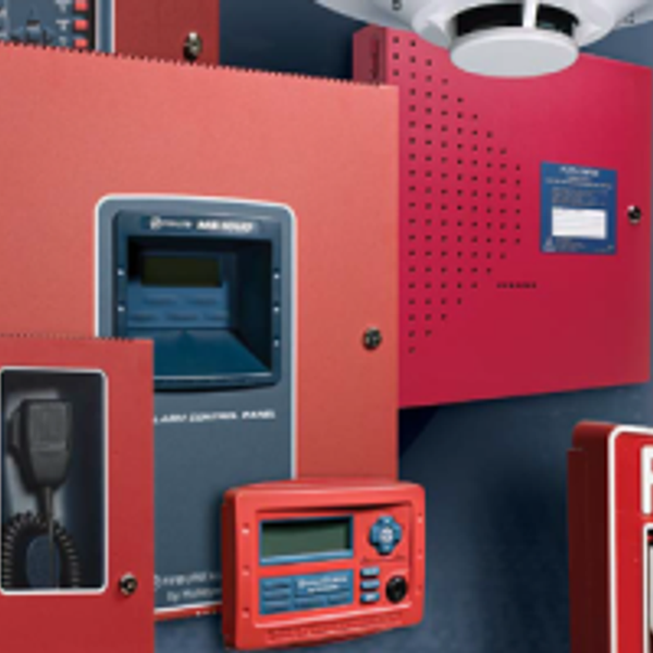 Red fire alarm control panels and communication devices mounted on a wall.