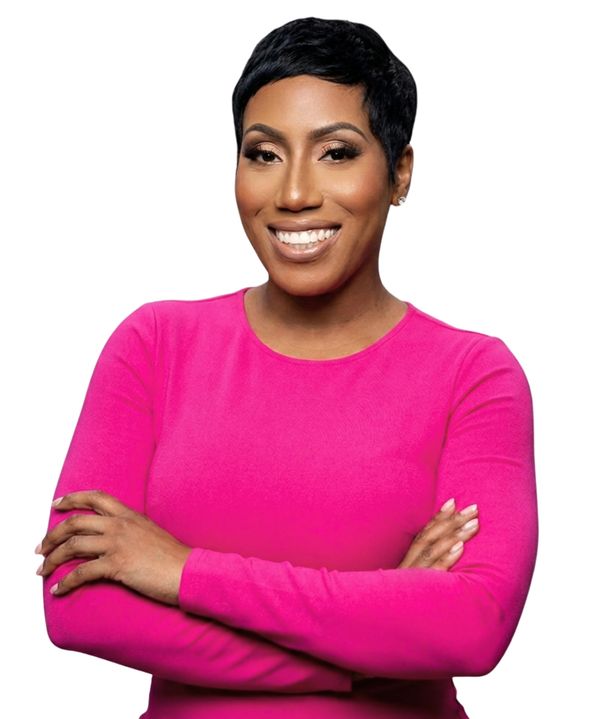Smiling woman in a pink top with crossed arms.