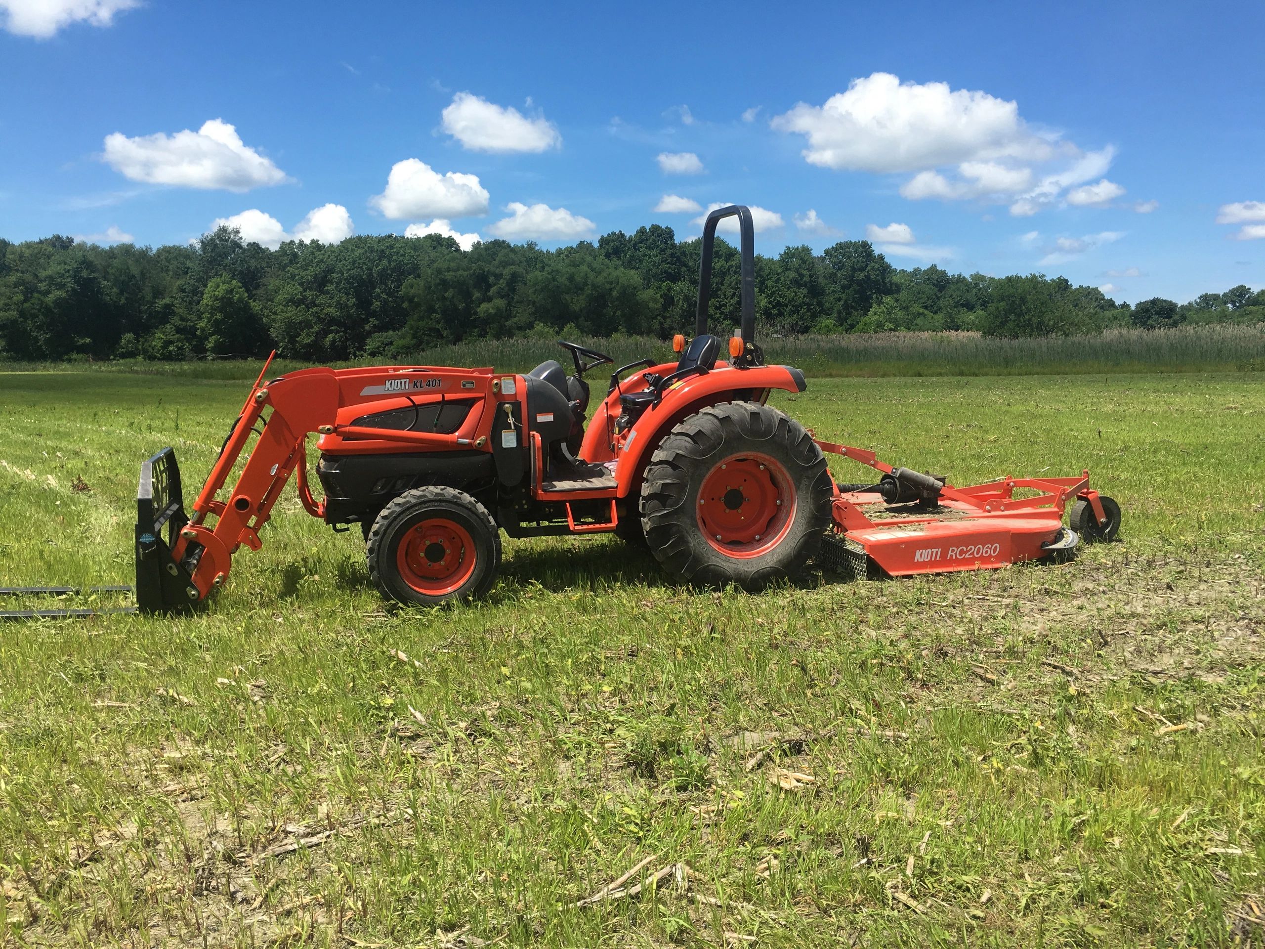 Tractor with loader, forks, rotary cutter bush-hog, chipper, chain saws, log splitter, live edge woo