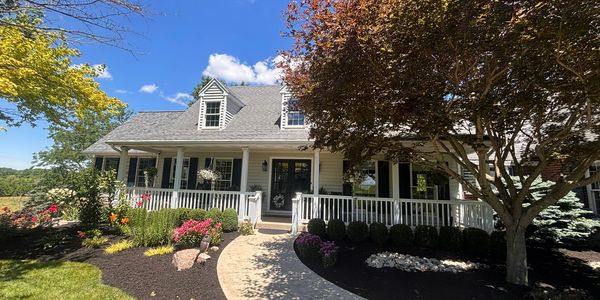 Charming house with a well-maintained front yard on a sunny day.