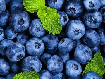 Fresh blueberries with vibrant green mint leaves.