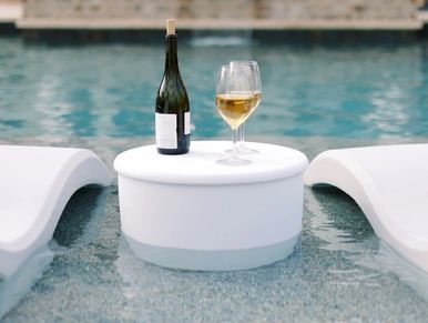Photo of Pool Lounger, in-pool Side Table in White on a pool ledge, pool self with Glass of wine.