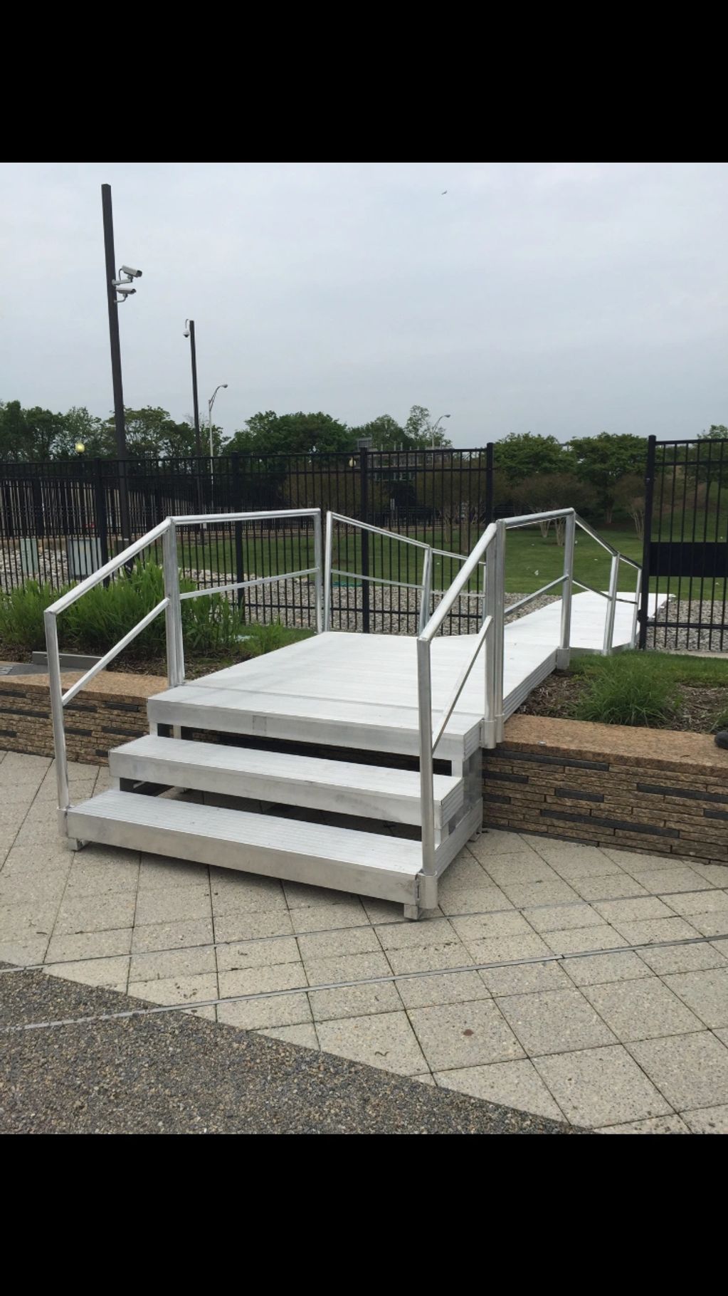 Staircase leading to the adjustable elevated walkway with railings for support. 