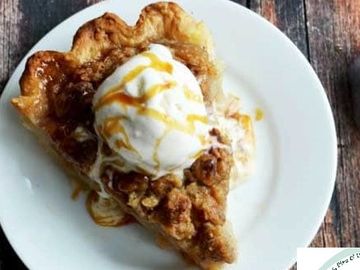 Slice of warm pie topped with vanilla ice cream and caramel drizzle.