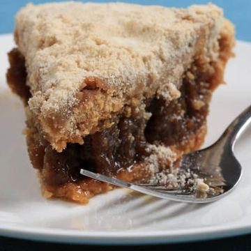 A slice of pecan pie with a crumbly topping on a white plate.