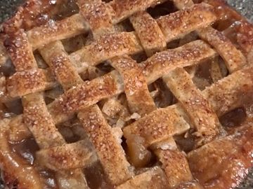 Golden-brown lattice apple pie with a sugary crust.