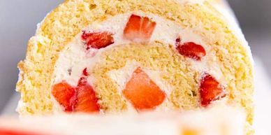 Close-up of a strawberry cream Swiss roll cake slice.
