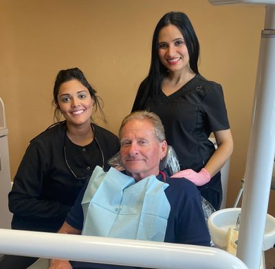 Dentist posing with a patient after doing a deep cleaning/scaling and root planing.