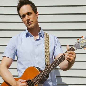 Man playing guitar outdoors.