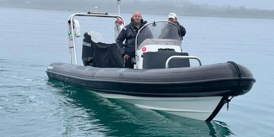 Two people in a powerboat with flags on it