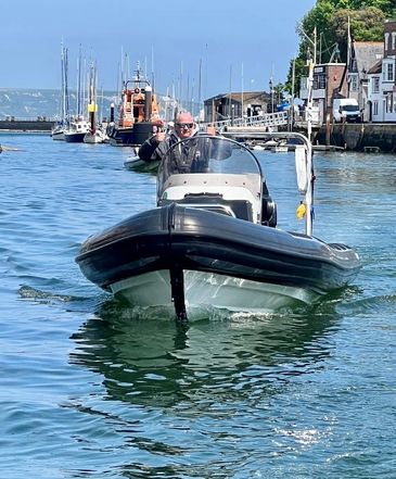 Powerboat in Weymouth Harbour on a sunny day  in front of the RNLI lifeboat