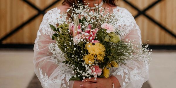 Bride holding a colorful flower bouquet.