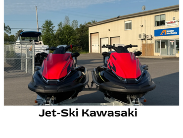 Two red Kawasaki jet skis parked side by side.