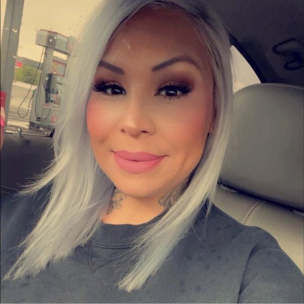 Woman with platinum blonde hair smiling inside a car.