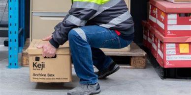 Man lifting a box in a warehouse.