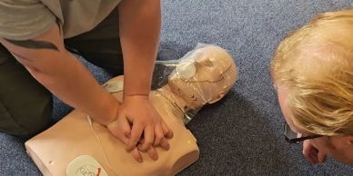 Person performing CPR on a training mannequin.