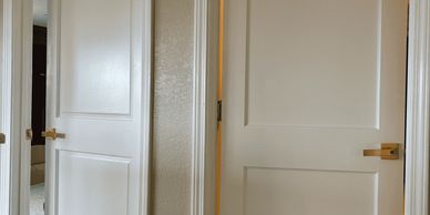 Two-panel interior doors and trim, installed and painted by Beattie Home RenovationsPerson using a n