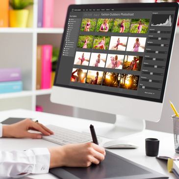 Person editing photos on a computer using a graphic tablet in a colorful workspace.