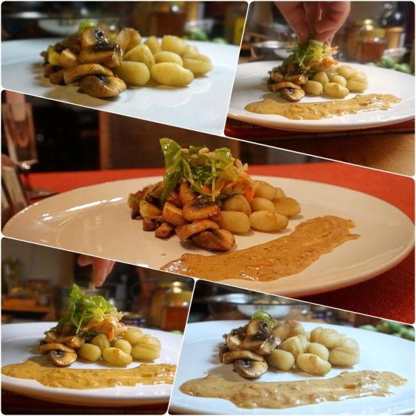 Gnocchi mit Pilzen und Sauce auf weißem Teller, angerichtet und verfeinert.