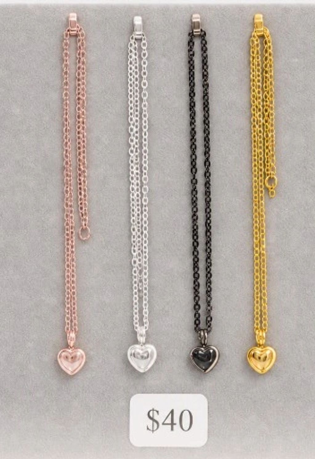 Four heart pendant necklaces in different colors.