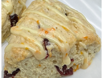 Close-up of a cranberry scone with icing drizzle.