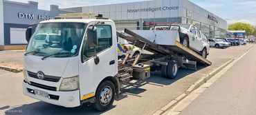 MHD Transport tow truck with its deck tilted down, preparing to offload a vehicle.