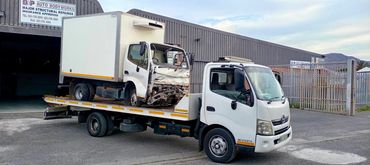 MHD Towing recovering and transporting a box truck on a flatbed in Cape Town industrial area.