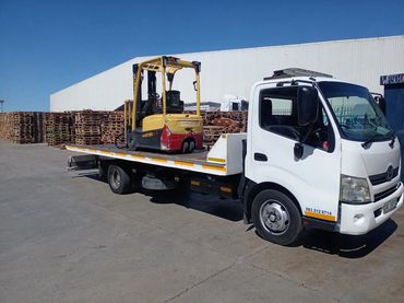 Flatbed recovery truck transporting a heavy-duty forklift for commercial relocation in Cape Town.