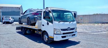 Flatbed tow truck transporting a BMW in Cape Town.
