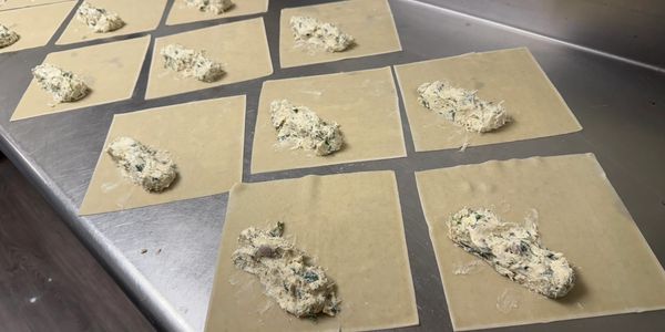 Preparing the Crab Eggrolls, Lump Crab with Honey Soy Cream Cheese, with red onions and arugula.   #