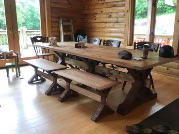 Massive triple trestle leg table with dual trestle leg benches.  Table top is reclaimed wormy chestn