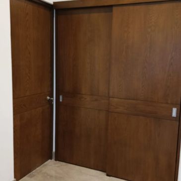 Wooden sliding and hinged doors in a corner room setup.