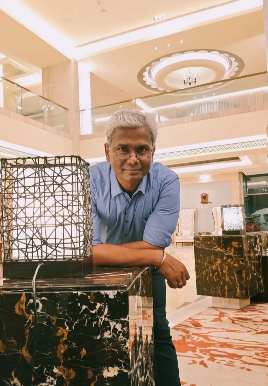 Man leaning on a marble counter in a stylish, well-lit lobby.