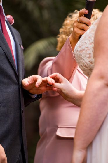 Couple exchanging rings during wedding ceremony.