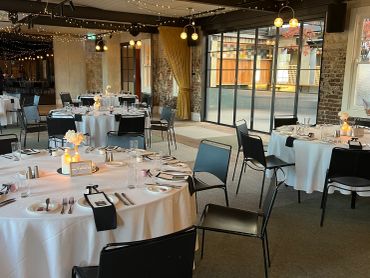 Elegant reception set with white tablecloths and warm lighting.
