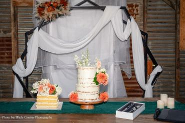 Rustic wedding cake with flowers and candles.