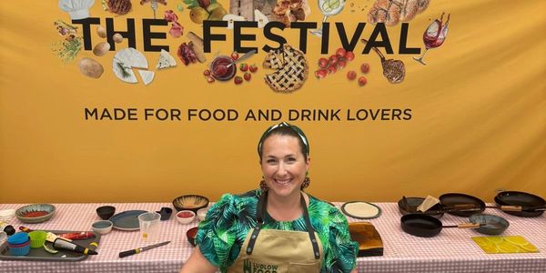 Smiling woman at a food festival booth.