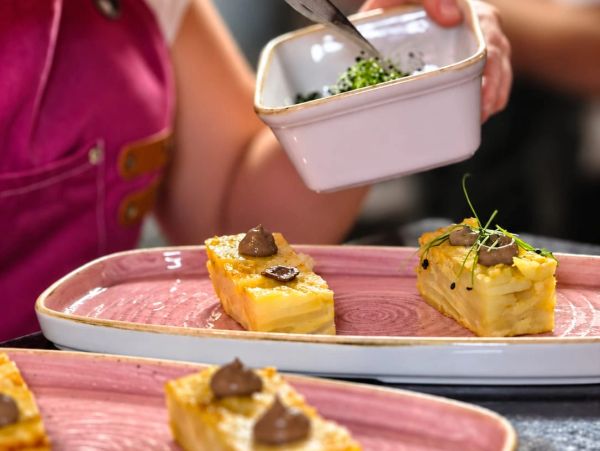Chef garnishing elegant dishes with herbs.