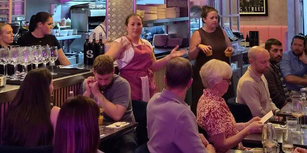People dining and staff interacting in a restaurant.