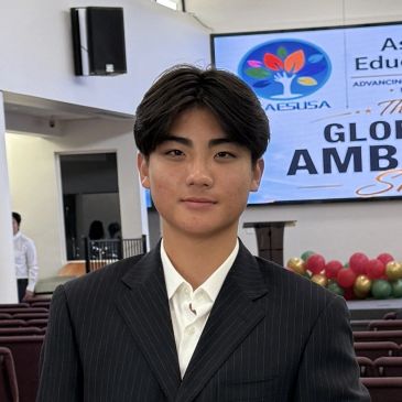 Young man in a suit posing confidently indoors.