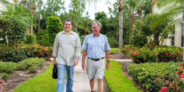 Father and son business partners walking and smiling.