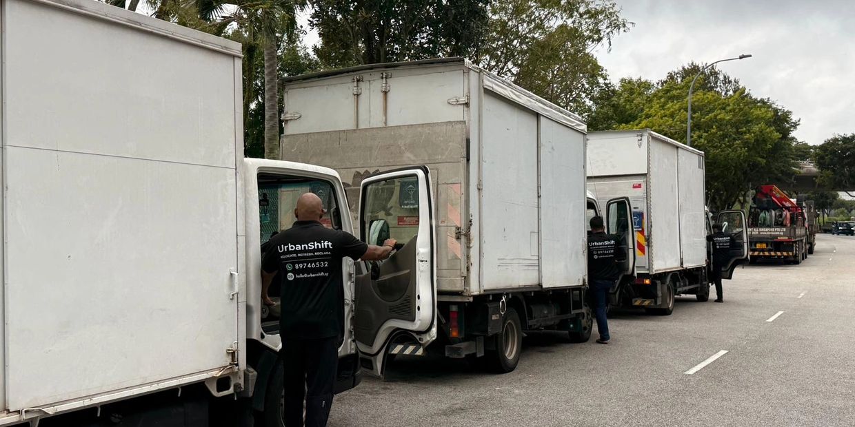 Workers with UrbanShift trucks lined up on a street.