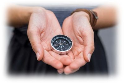Person holding a compass in cupped hands.