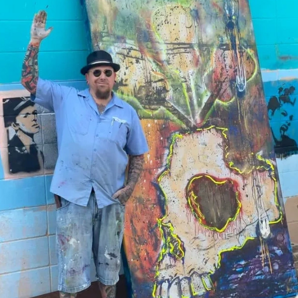 Nathanarchy standing in front of "Why do I want to Die" an original 8 ft by 4 foot canvas.